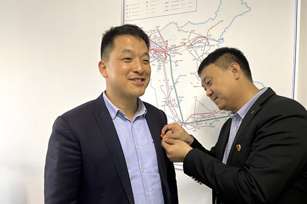 1648092486372444.jpg 支部書記為黨員佩帶黨徽.JPG